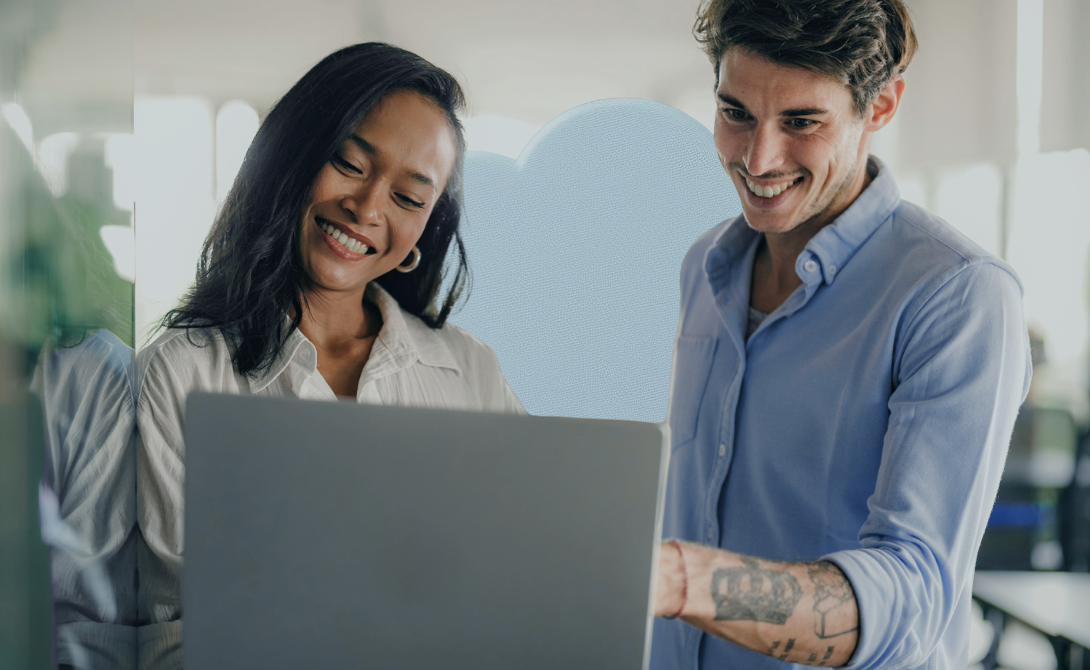 Two smiling colleagues looking at a laptop in a modern office – cloud computing benefits and collaboration