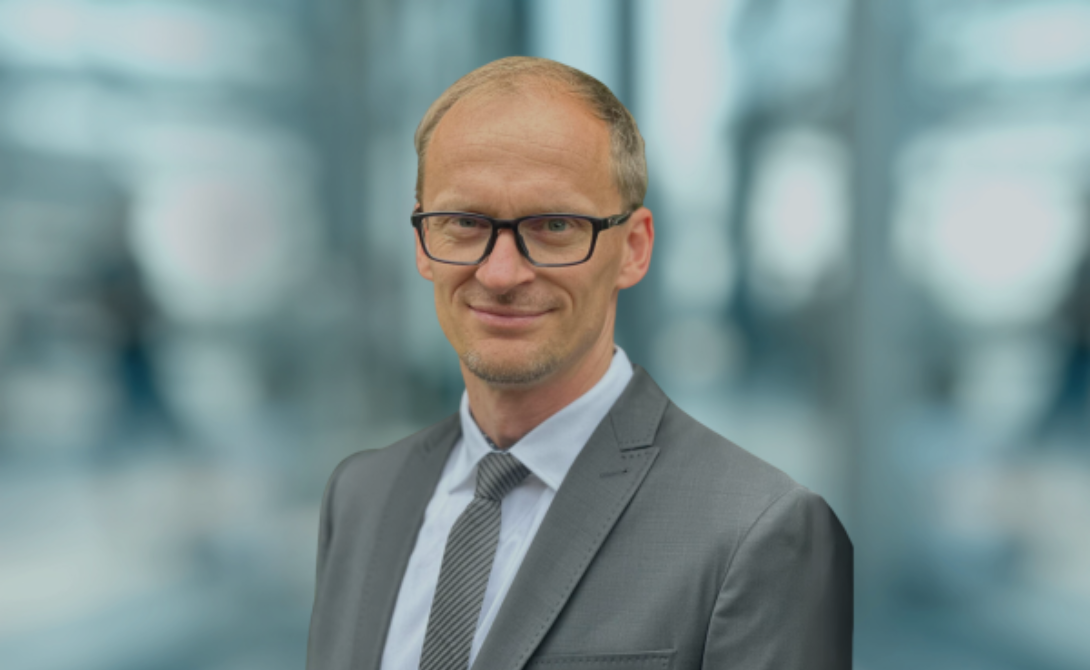 Portrait of Henri Schmidt in a business suit – representing his insights on how CONVOTIS is shaping the digital future of HR.