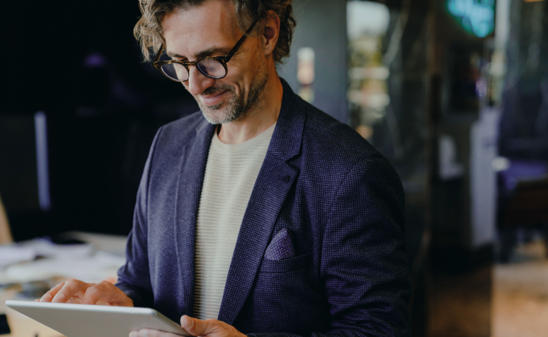 Professional using a tablet in a modern office – illustrating a Managed Digital Workplace with secure device access and flexible work environments.