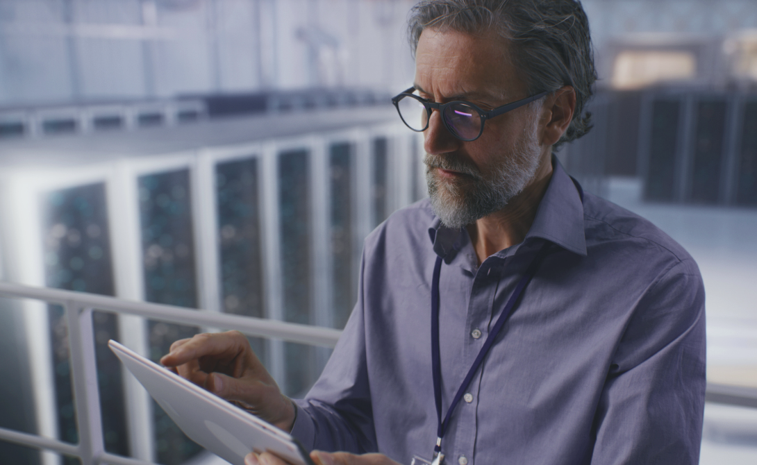 IT expert managing hybrid and multi-cloud infrastructure on tablet in a data center environment