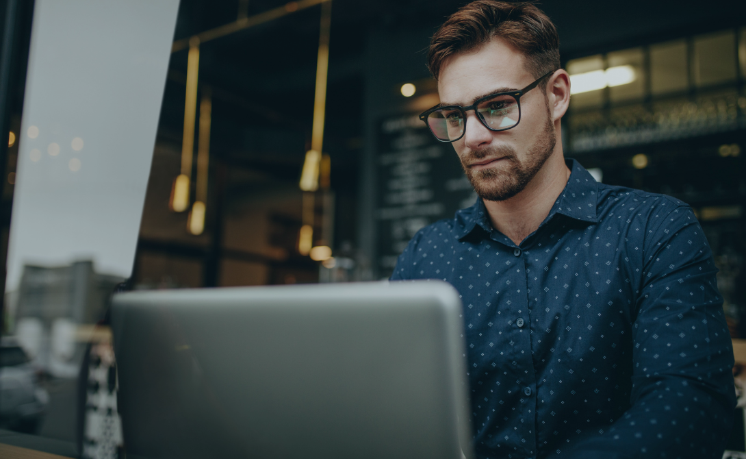 IT professional working on cloud computing risk analysis on a laptop in a modern workspace