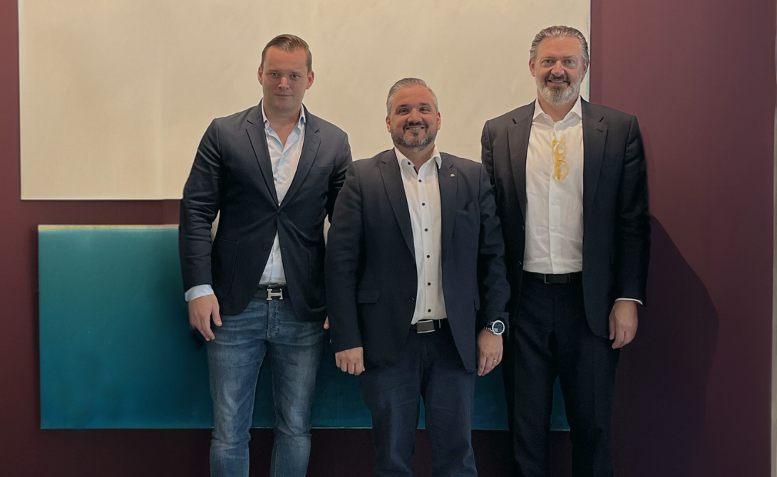 Three business professionals standing together and smiling – representing the announcement that aspectra AG is joining the CONVOTIS Group.