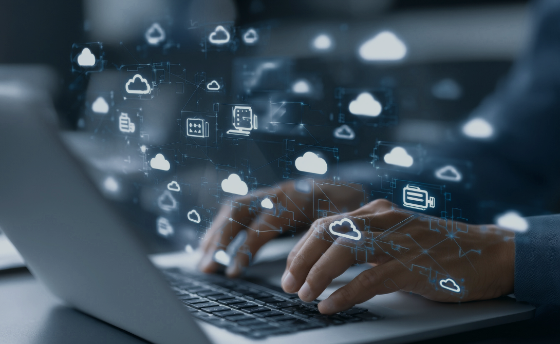 Hands typing on a laptop with floating cloud icons – representing enterprise cloud migration and digital infrastructure transformation.