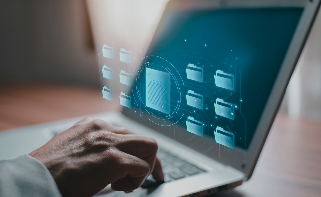 Hand on a laptop keyboard with glowing digital folders and a document icon – symbolizing workflow automation and intelligent platform implementation.