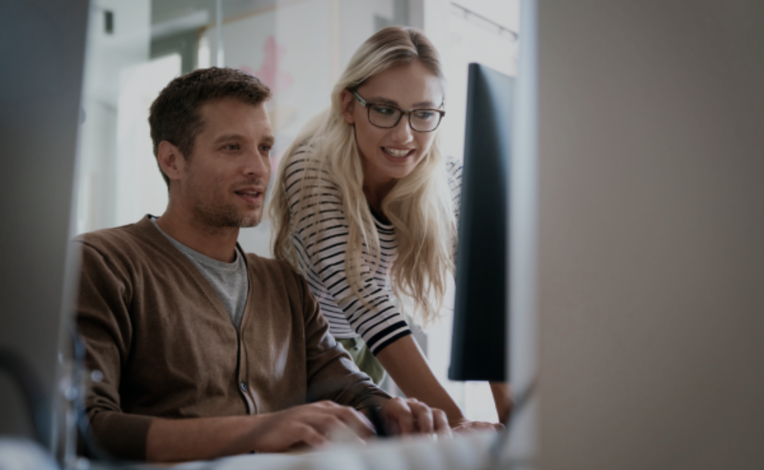Two professionals discussing virtualization strategies on a laptop – representing modern IT infrastructure planning and digital transformation.