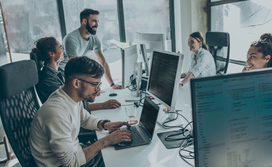 Team collaborating on custom software development project – developers working together in modern office environment