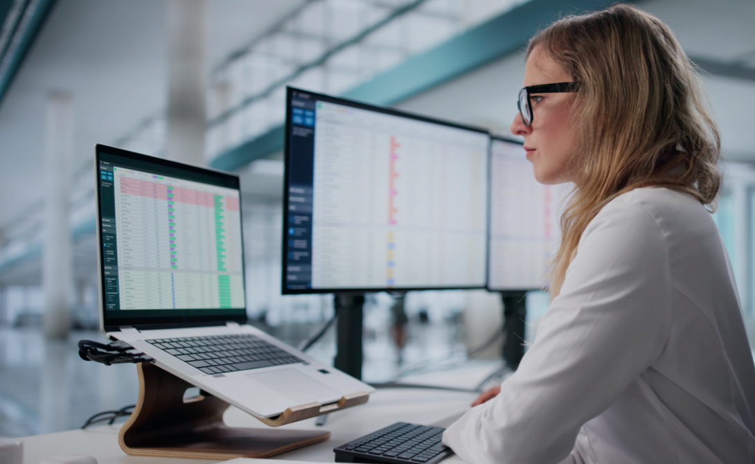 An empoyee looking at her laptop and searching for OpenText xECM.